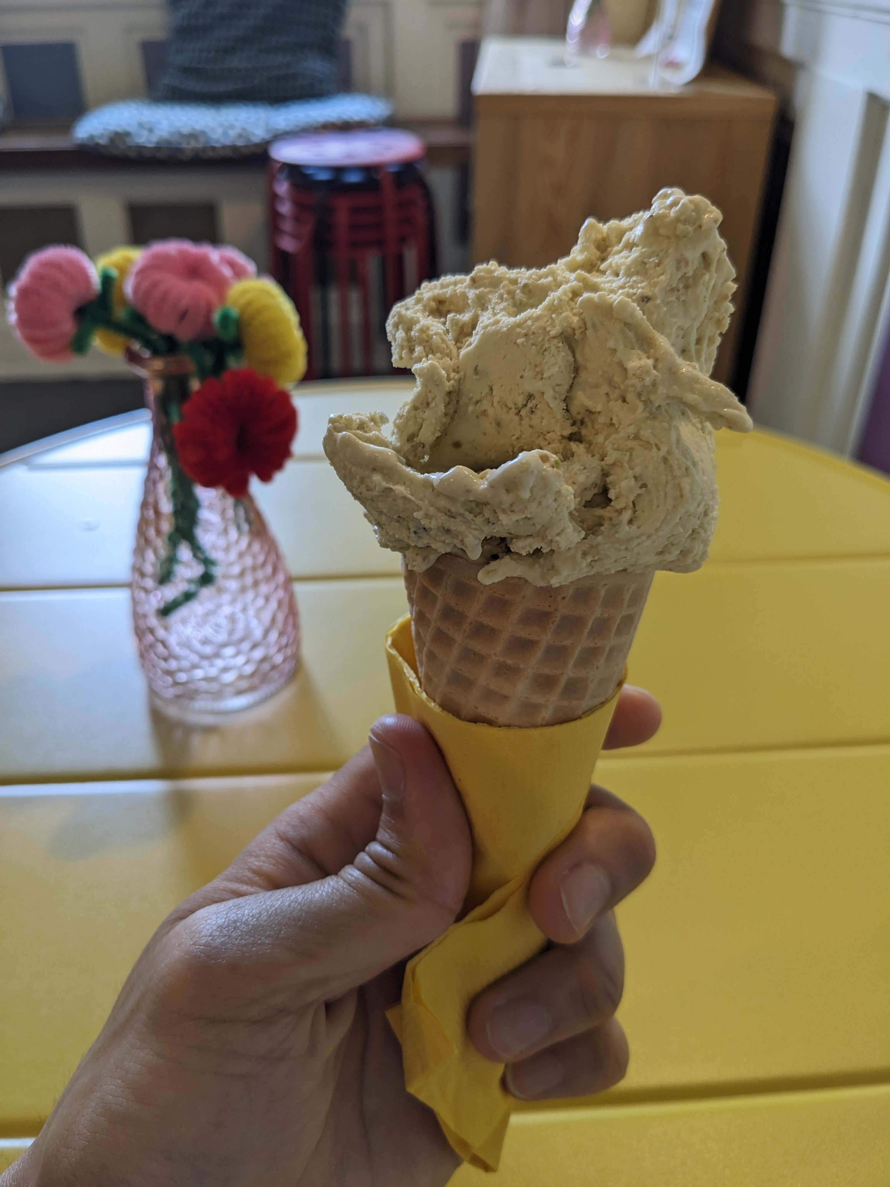 a wild scoop of pistachio gelato on a cone